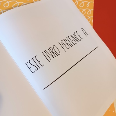 Página de livro com texto 'ESTE LIVRO PERTENCE A:' e uma linha para preencher nome