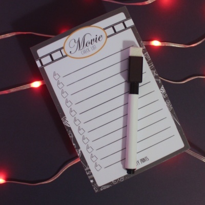 Bloco de notas para lista de filmes com caneta e luzes vermelhas