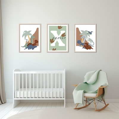 Três quadros infantis com dinossauros e letra X na parede de quarto de bebé com berço branco e cadeira de baloiço