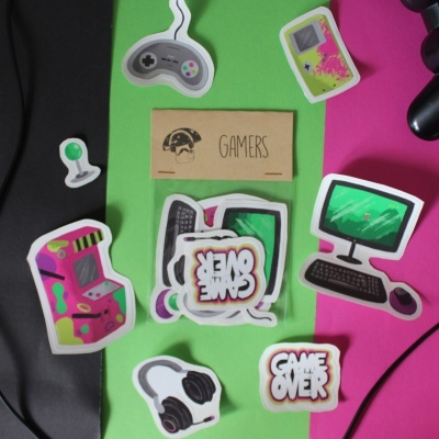 Autocolantes com temas de videojogos sobre fundo preto, verde e rosa.