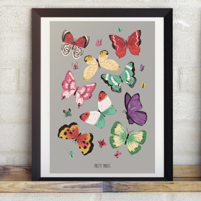 Poster emoldurado com várias borboletas coloridas sobre fundo cinzento e texto PRETTY PRINTS