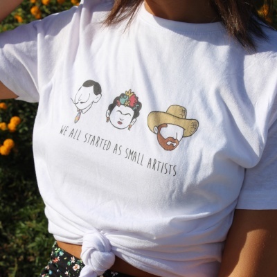 T-shirt branca com caricaturas e texto WE ALL STARTED AS SMALL ARTISTS