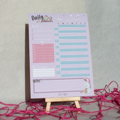 Bloco de planeamento diário com cores pastel, ilustração de coelho e cavalete de madeira