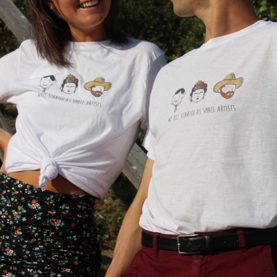 T-shirts brancas com desenhos de rostos e texto WE ALL STARTED AS SMALL ARTISTS
