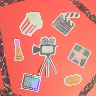 Autocolantes de cinema coloridos em fundo vermelho com borda decorativa