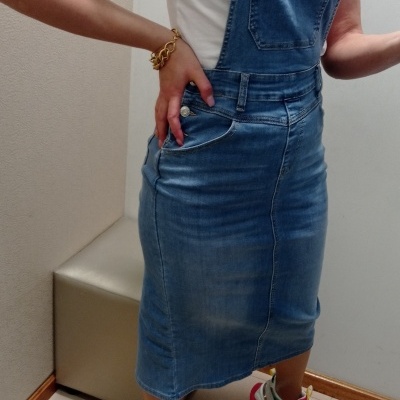 Vestido jardineira em ganga azul médio com bolso frontal, t-shirt branca e sapatilhas multicoloridas