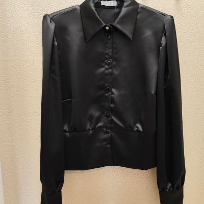 Camisa preta acetinada com botões e gola clássica pendurada