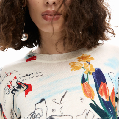 Mulher com camisola branca estampada com padrão colorido abstrato e flores