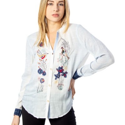 Camisa branca com bordados coloridos e punhos azuis escuros.