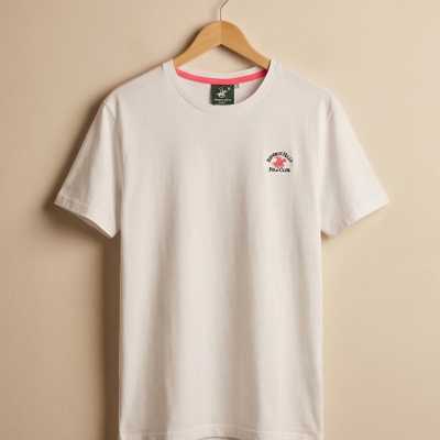 T-shirt branca com logótipo no peito pendurada num cabide de madeira