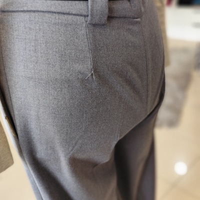 Calças cinza com cinto preto e camisa bege