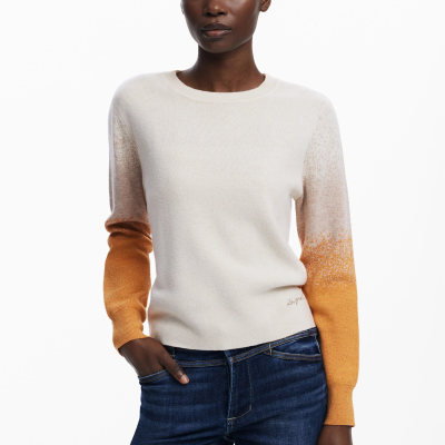 Camisola de malha feminina bege com mangas em degradê castanho claro e laranja combinada com jeans escuros.