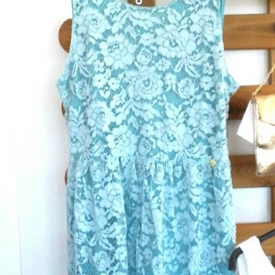 Vestido azul claro de renda com padrão floral pendurado num cabide