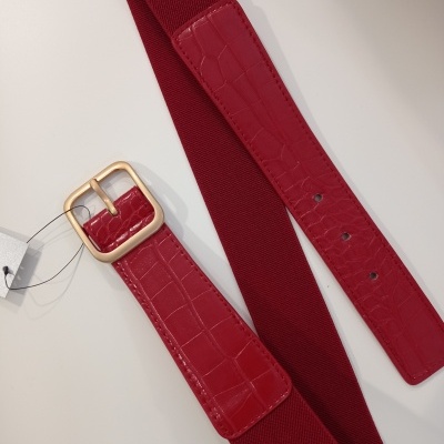 Cinto vermelho com fivela dourada e textura imitando pele de crocodilo