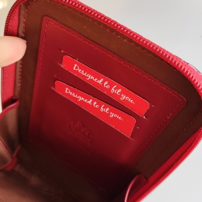 Carteira em pele vermelha com interior castanho e dois cartões Designed to fit you.