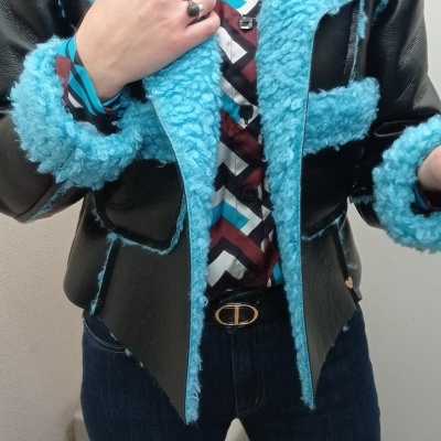 Casaco preto com pêlo azul turquesa e camisa geométrica colorida