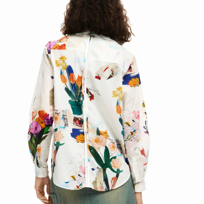 Blusa branca estampada com flores coloridas vista de costas com saia de ganga azul.