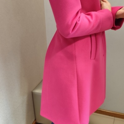 Casaco rosa comprido e jeans azul com botas castanhas