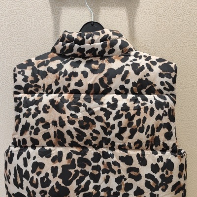 Casaco acolchoado padrão pele de leopardo pendurado em cabide