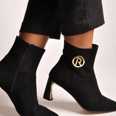 Botas pretas com salto dourado e detalhe dourado circular com letra R