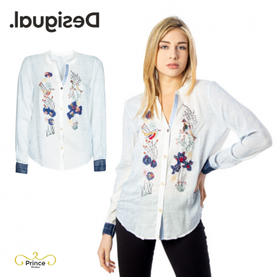 Camisa branca bordada com flores coloridas e punhos azuis escuros usada por modelo