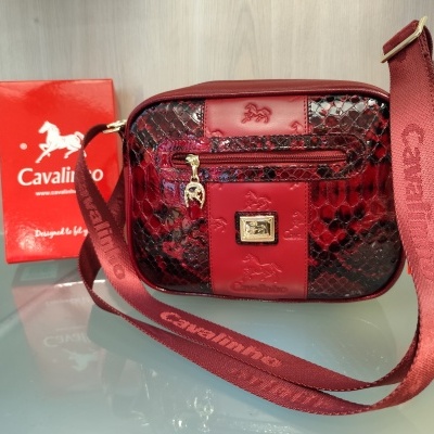 Bolsa de ombro Cavalinho vermelha com padrão imitação pele de cobra e alça com o texto Cavalinho