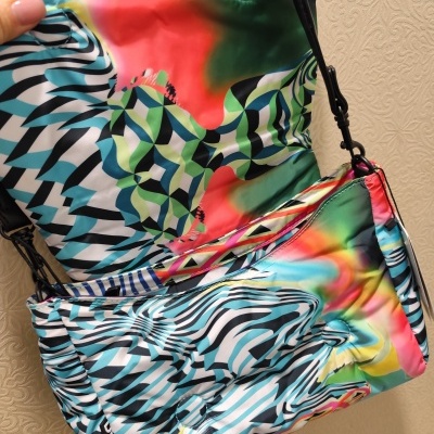 Mala colorida com padrão psicadélico e alça preta