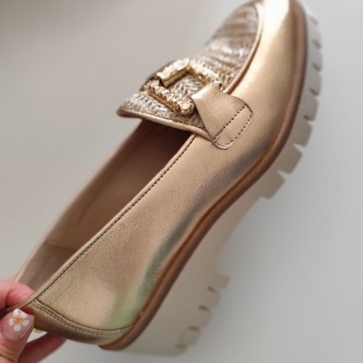 Mocassim feminino dourado com fivela decorativa e sola branca