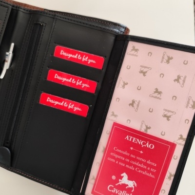 Carteira preta de pele aberta com cartões vermelhos e adesivo Cavalinho