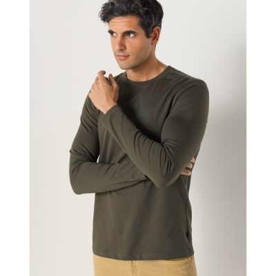 Homem com camisola de manga comprida verde-oliva e calças bege, fundo branco