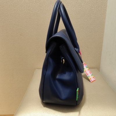 Mala azul escura com alças grossas e detalhes coloridos ao lado