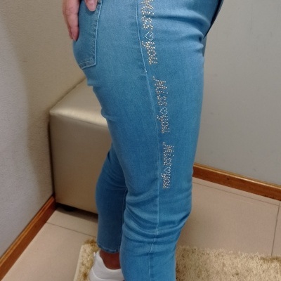 Calças de ganga azuis claras com aplicação de pedras brilhantes e pessoas a usar