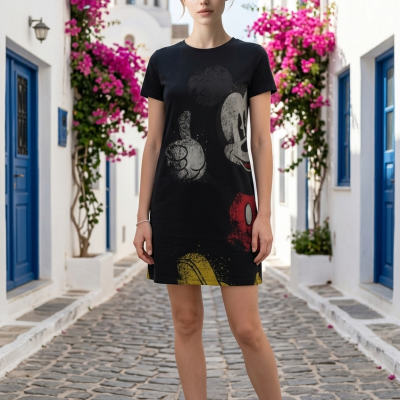 Mulher com vestido preto estampado de Mickey Mouse em rua tradicional com pedras, flores rosas e portas azuis.
