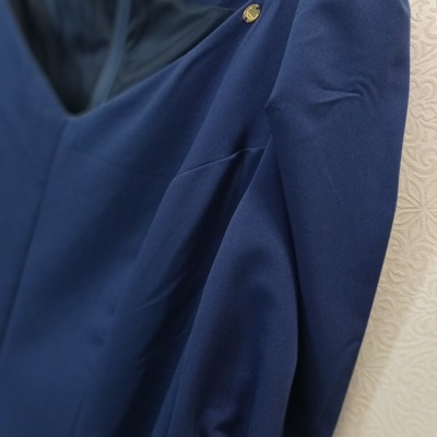 Vestido azul escuro com mangas bufantes e botão dourado