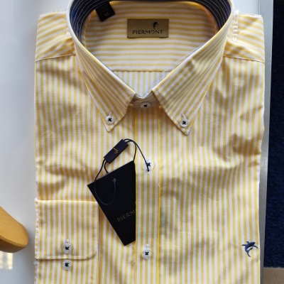 Camisa de algodão riscada amarela e branca dobrada com etiqueta PIERMONT.