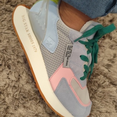 Ténis multicoloridos em superfície de carpete, detalhes de malha e camurça com sola branca e texto 'BIG STAR SHOES 1979'