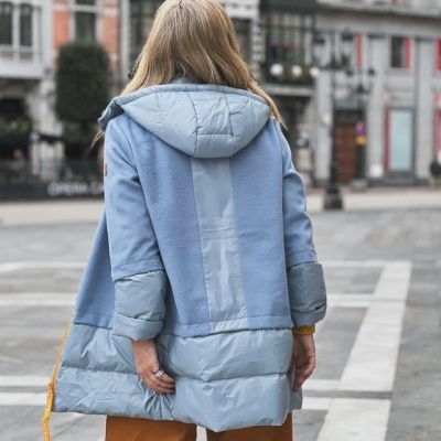 Casaco feminino azul claro com capuz visto por trás numa rua da cidade