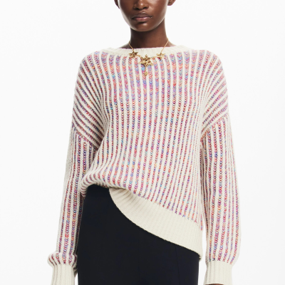 Mulher com camisola riscada colorida e calças pretas em fundo branco