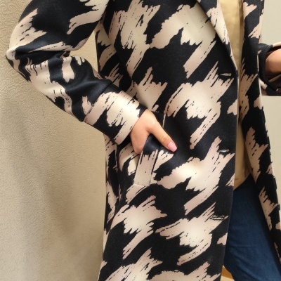 Casaco longo preto e bege com padrão abstrato em detalhe