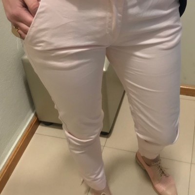 Calças rosa claro com botão e elástico, camisa floral e sapatos rosas