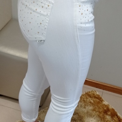 Calças brancas justas com cristais nos bolsos e sapatos brancos