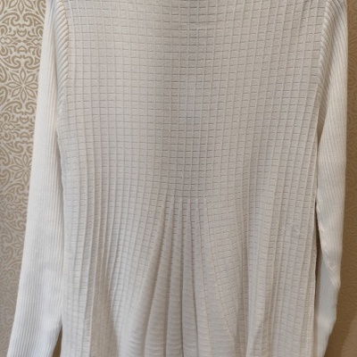 Blusa branca de malha com gola alta pendurada