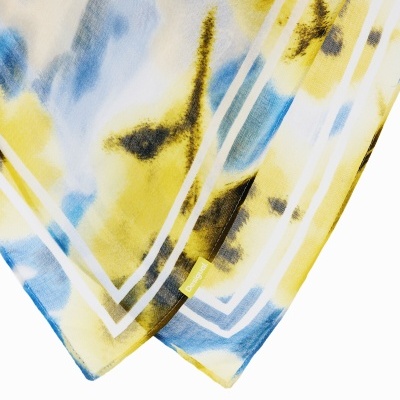 Pano com padrão abstrato amarelo, azul e preto e etiqueta Desigual