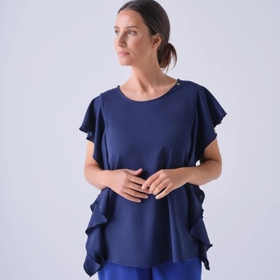 Mulher a usar top azul escuro com mangas curtas e detalhes ondulados nas laterais e calças azuis