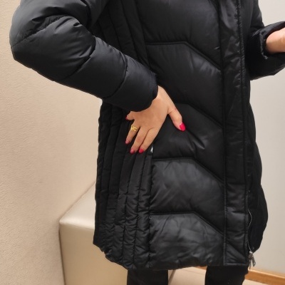 Casaco acolchoado preto com capuz de pêlo usado por pessoa