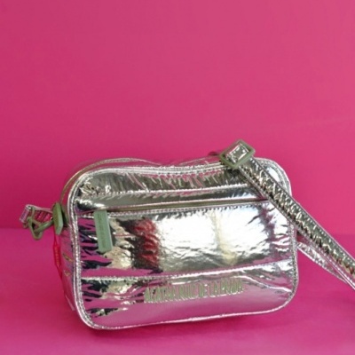 Mala de ombro metálica prateada sobre fundo rosa