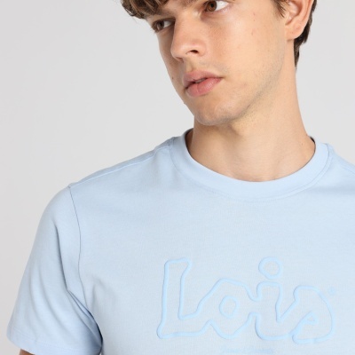 Camiseta azul clara com logo Lois em relevo usada por homem