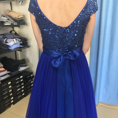 Vestido azul com lantejoulas e saia plissada visto pelas costas.