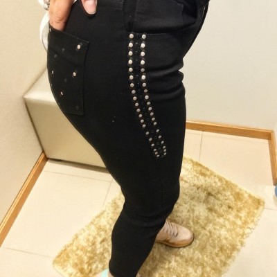 Calças justas pretas com tachas prateadas na lateral e bolso traseiro