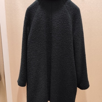 Casaco preto com textura felpuda pendurado num cabide